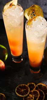 Two tall glasses of citrus cocktails with fruit slices.