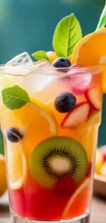 Colorful citrus fruit cocktail with ice and berries in a glass.