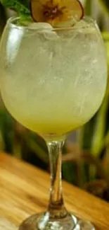 A refreshing cocktail in a glass with a fruit garnish on a wooden surface.