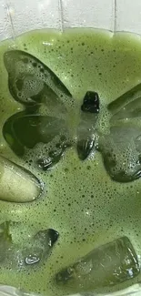 Vibrant green drink with butterfly ice cubes in a glass.