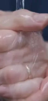 Hands being washed with flowing water, promoting cleanliness.