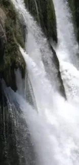 Waterfall cascading down rocks in a lush natural setting.