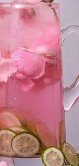 Pink lemonade pitcher with rose petals and lime slices.