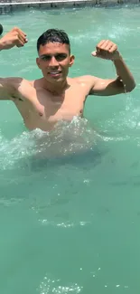 Young man enjoying a sunny swim in a vibrant turquoise pool.