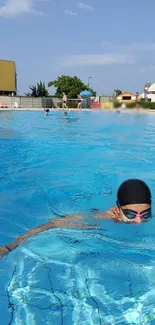 A swimmer enjoying a sunny day in a clear blue swimming pool.