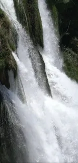 Dynamic waterfall cascading over rocks in a lush, green forest setting.