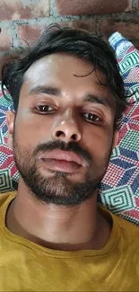 Man resting on colorful pillow with a relaxed expression.