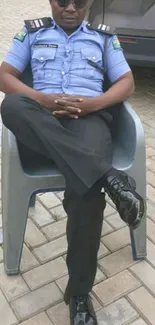 Police officer sitting relaxed in a chair outdoors in uniform.