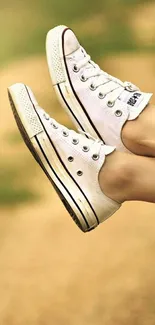 Relaxed legs in sneakers hanging from a car window on a sunny road trip.