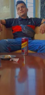 Young man relaxing with a soda can indoors.