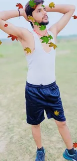 Man in a relaxed pose with falling autumn leaves outdoors.