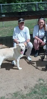 A couple sitting with a dog in a sunny park.