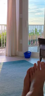 Relaxing ocean view from a sunlit room with open balcony doors.