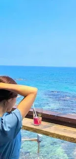 Woman enjoying a serene ocean view from a beachside cafe, perfect for relaxation.