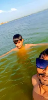 Two people swimming in a calm lake with clear green water.