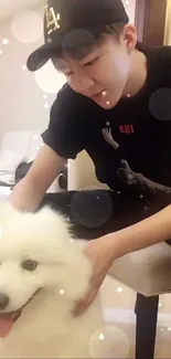 Young man petting a fluffy white dog indoors.