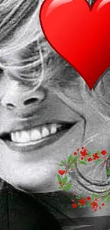 Smiling woman with red heart overlay on black and white wallpaper.