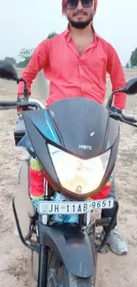 Man riding a black Hero motorcycle in a scenic outdoor setting.