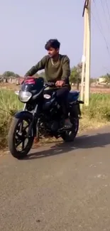 Motorcyclist rides on scenic country road.