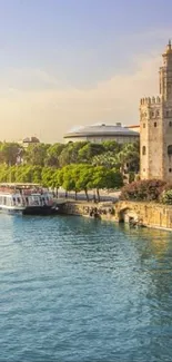 Serene view of Seville's Torre del Oro by the riverside under a sunny sky.