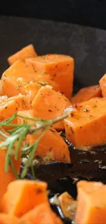 Close-up of roasted sweet potato slices with herbs.