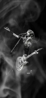 Black and white wallpaper of a guitarist performing on stage.