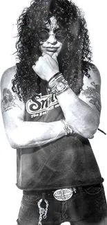 Black and white image of a rock star in stylish attire with tattoos.