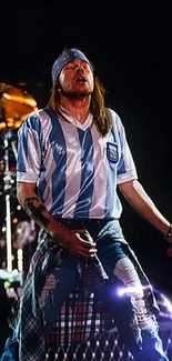 Rock musician in striped jersey performing live.