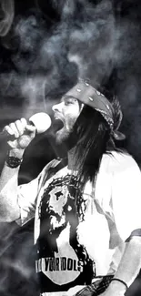 Singer performing on stage in black and white with smoky background.