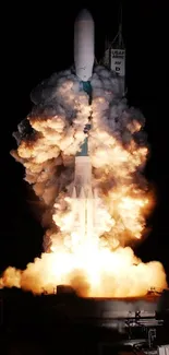 Nighttime rocket launch with blazing flames.