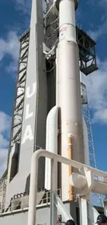 Rocket standing on launchpad with blue sky backdrop.