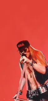 Rockstar performing on a red stage background.