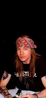 Rock musician with bandana and tattoos on black background.