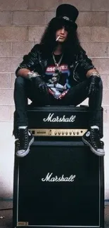 Rockstar sitting on Marshall guitar amp in edgy attire.