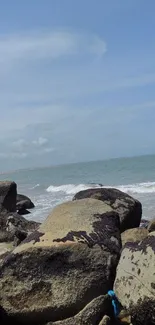 Rocky beach with ocean view and blue sky.