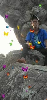 Person sitting on a rocky cliff under a clear sky.