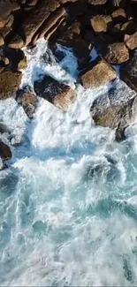 Aerial view of ocean waves crashing against rocky shoreline.