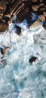 Aerial view of ocean waves crashing against rocky shore in blue hues.