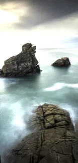 Calm ocean scene with rocky cliffs and cloudy sky, perfect for wallpapers.