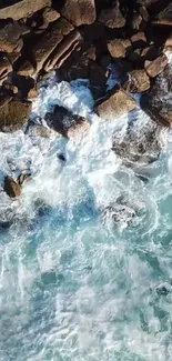 Aerial view of waves crashing against rocky shore, creating a dynamic coastal scene.