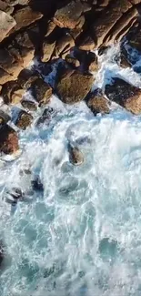 Aerial view of rocky shores with white waves crashing against them.