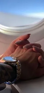 Romantic handholding in airplane window view.