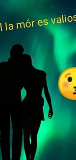 Silhouette couple under green aurora with a kiss emoji.