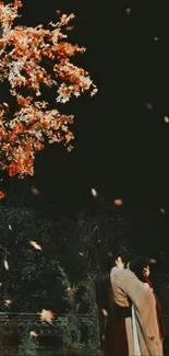 Romantic couple under falling autumn leaves at night.