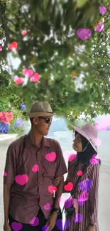 Couple on a serene beach with colorful hearts.