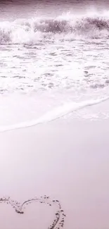 Lavender-toned beach with heart in sand and ocean waves.