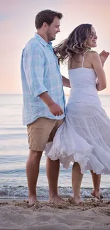 Couple walking on beach during sunset, peaceful scene.