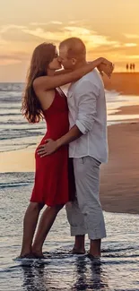 Couple kissing on a beach during sunset.