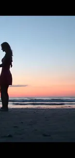 Romantic couple silhouette during sunset on a beach.