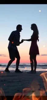 Silhouette of a couple enjoying a vibrant beach sunset.